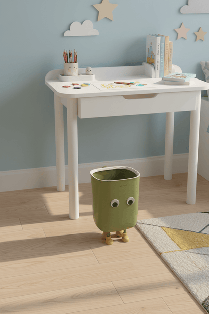 Poubelle BuddyBin verte dans une chambre d’enfant près d’un bureau